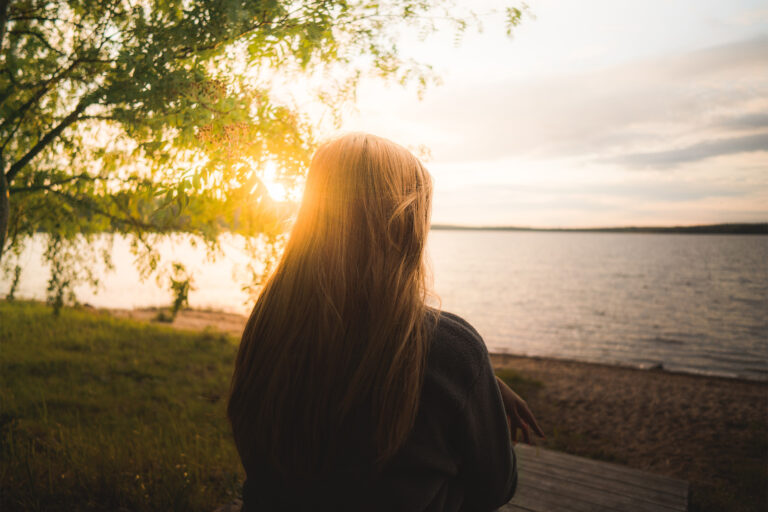 young woman looking at the serene landscape in Revontuli Resort