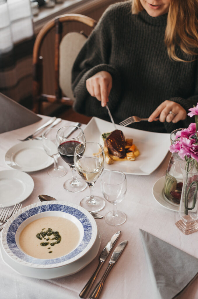 a close up photo of a woman eating dinner in restaurant Loimu