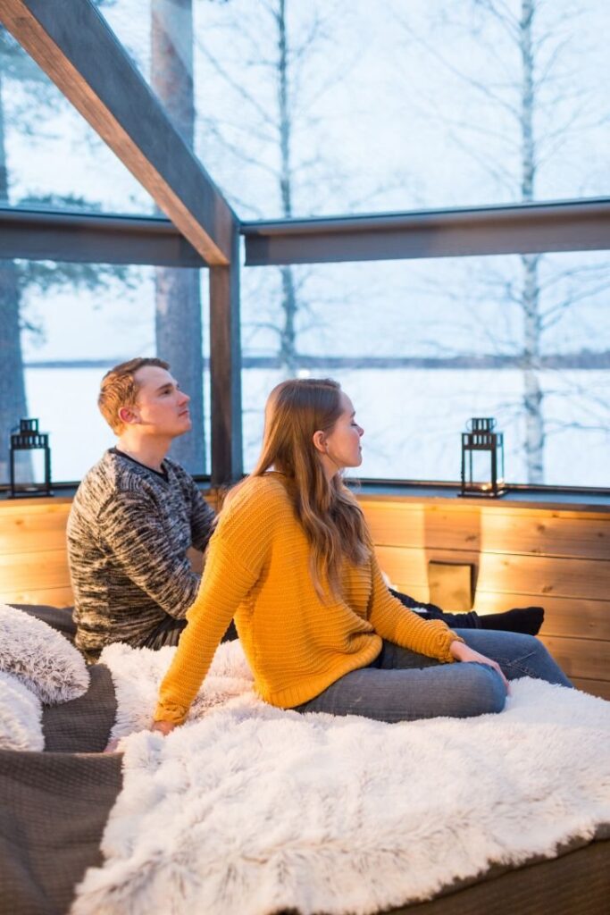 couple relaxing on the bed in Deluxe Kuiske Glass Igloo
