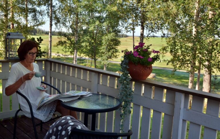 Woman enjoying coffee on a terrace at Cabin Aurora