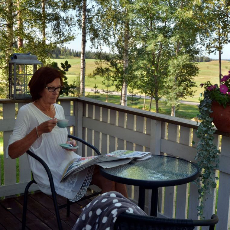 Woman enjoying coffee on a terrace at Cabin Aurora