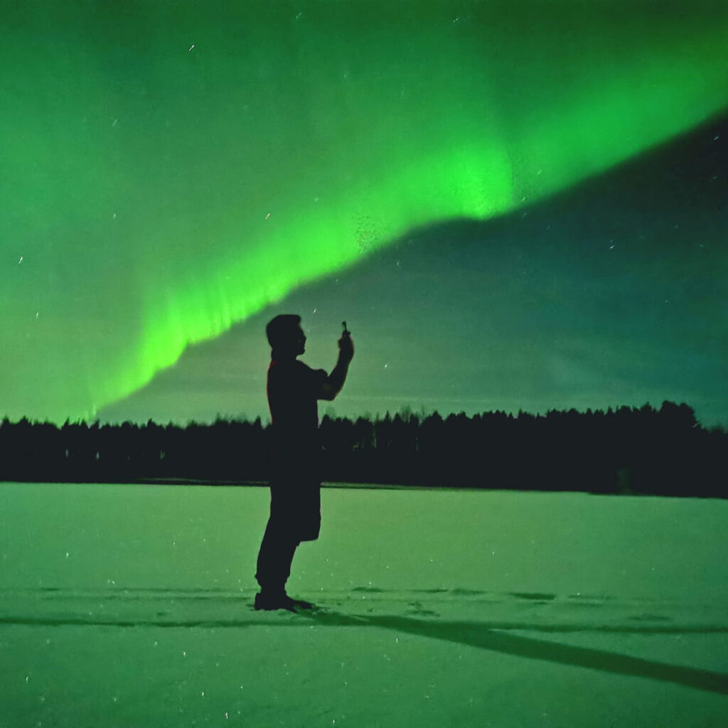 man photographing northern lights