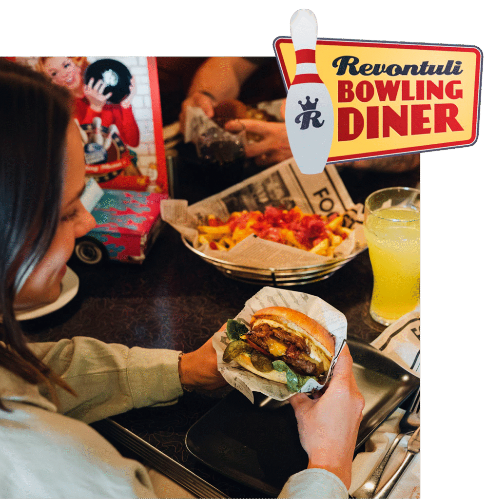 nainen syö hampurilaista bowling dinerissa