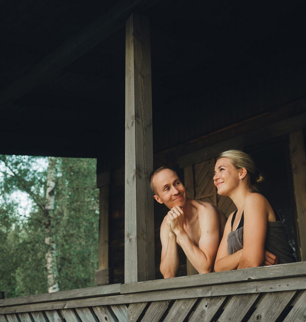 pariskunta rentoutuu saunan terassilla